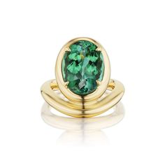 a ring with a green stone in the center and two gold rings on each side