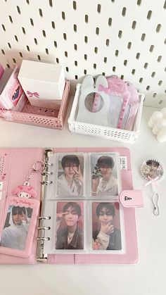 an open pink binder with photos on it next to other items and accessories in the background