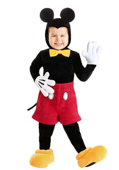 a little boy in mickey mouse costume standing with his hands up and smiling at the camera