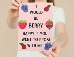 a woman holding up a card that says i would be berry happy if you went to hoco with me