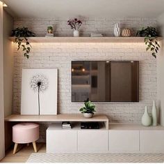 a living room with white brick walls and plants on the shelves above it, along with a pink ottoman