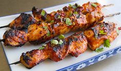 chicken skewers with cilantro and parsley on a blue and white plate