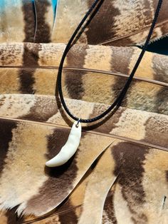 an animal print necklace with a white pendant