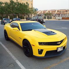 a yellow chevrolet camaro parked in a parking lot