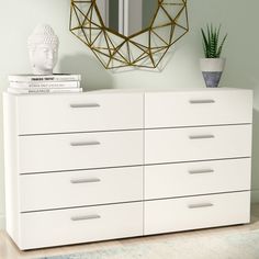 a white dresser sitting in front of a mirror