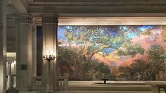 a large painting in the middle of a building with columns and chandeliers on either side