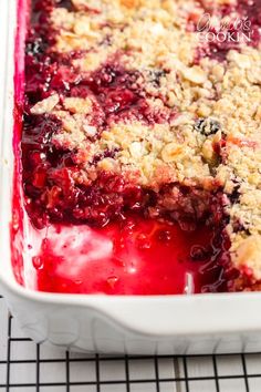 berry cobbler with crumbled toppings in a white dish on a cooling rack