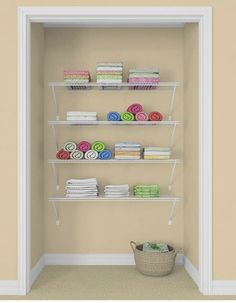 an open closet with shelves and towels on the wall