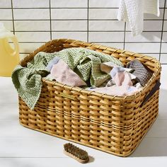 a wicker basket filled with clothes next to a brush