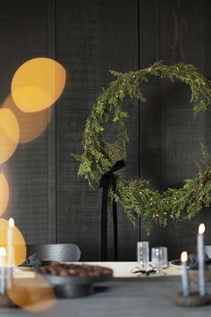 a table topped with a wreath and candles