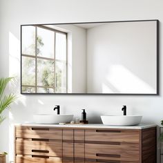 a bathroom vanity with two sinks and a large mirror over the sink, in front of a window