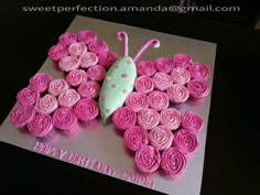 a birthday cake decorated with pink icing and a butterfly