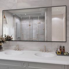 a bathroom with two sinks and a large mirror on the wall above it's counter