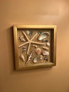 a wooden frame with seashells and starfish on it