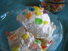 two pieces of cake with gummy bears on top in a glass bowl next to some candy