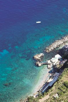 an aerial view of a beach with boats in the water