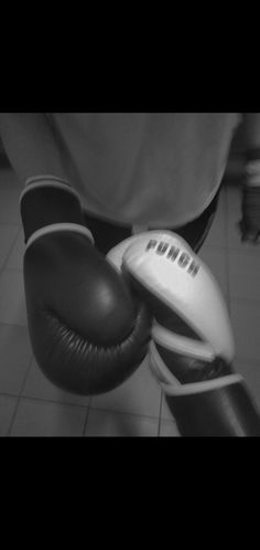 a close up of a person wearing boxing gloves and holding a punching glove in their right hand