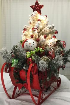 a small christmas tree in a red sleigh with lights and decorations on it