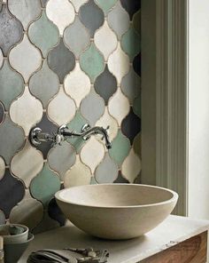 a bowl sink sitting on top of a counter next to a wall mounted faucet