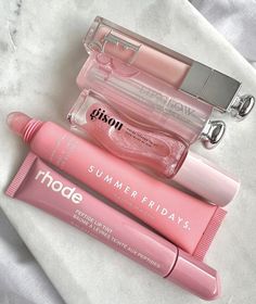 three lip glosses are laying next to each other