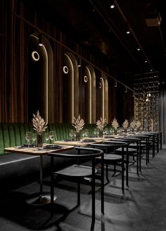 an empty restaurant with green velvet booths and black tables set up for dinner or lunch