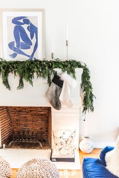 a living room decorated for christmas with stockings on the fireplace mantel and other decorations