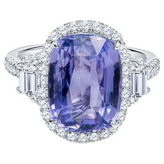 This beautiful cocktail ring features a 5.68 cushion cut natural violet sapphire accented by 0.55 carat total weight in round diamonds and 0.34 carat total weight in two step cut trapezoid diamonds. The cocktail ring is set in platinum and is currently a size 6 but can be resized upon request. This sapphire and diamond cocktail ring can be worn everyday or saved for special occasions. Measurements: Sapphire measures 12.25 x 9.18 x 5.10mm Report: Report: Reunigem FK58560314 Luxury Purple Sapphire Ring For Wedding, Luxury Classic Amethyst Cushion Cut Ring, Violet Sapphire, Sapphire Cocktail Ring, Two Step, Diamond Cocktail Ring, Diamond Cocktail Rings, Shiny Things, Blue Jewelry