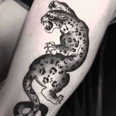 a black and white tattoo of a leopard on the leg