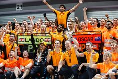 a group of people wearing orange shirts and holding up their hands in front of them