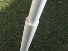 a white baseball bat sitting on top of a lush green field