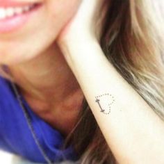 a woman with a small tattoo on her left wrist and the word love written in it