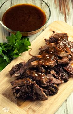 some meat on a cutting board with sauce and parsley