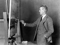 a man standing in front of an easel painting