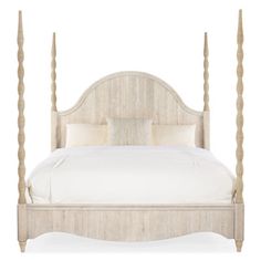 a white bed with four posts and pillows on it's headboard, in front of a white background