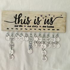 this is us keychain hanging on a wall with many different charms attached to it