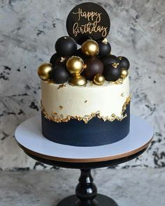 a birthday cake with gold and black decorations