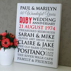 a white vase filled with red flowers next to a sign that reads ruby wedding anniversary