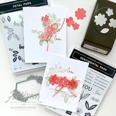 four cards with flowers on them sitting next to some scissors and other crafting supplies