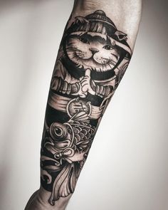 a person with a tattoo on their arm that has a cat and fish on it