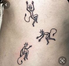 three small tattoos on the back of a woman's lower body, one with an upside down design