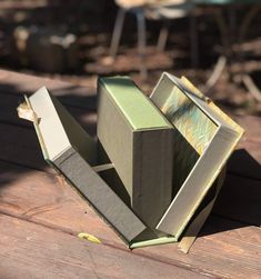 an open book sitting on top of a wooden table next to a chair and umbrella