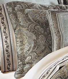 a close up of a bed with many pillows