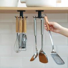 the kitchen utensils are hanging on the wall