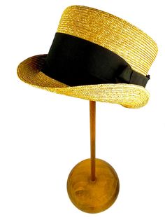 Straw topper hat in pork pie style. Made with very fine 5/6 millimeter natural straw braid. Adorned with an excellent 70 millimeters wide black grosgrain ribbon and finished with a beautiful bow to the right of the hat You can choose the color of the grosgrain ribbon from our color chart. The high-quality of the material provides the flexibility, lightness and resistance that this elegant hat deserves. Measurements in centimeters are 28 x 21. Crown height 11,5. These measurements may have some s Fitted Brimmed Panama Hat, Fitted Straw Hat With Short Brim, Classic Gold Hat For Summer, Adjustable Formal Straw Hat For Summer, Formal Adjustable Straw Hat For Summer, Adjustable High Crown Straw Hat, Classic Straw Hat With High Crown And Adjustable Fit, Classic High Crown Straw Hat With Adjustable Fit, Fitted Straw Fedora With Short Brim