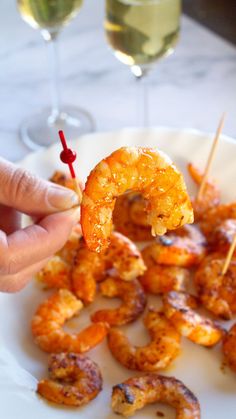 a person holding up a shrimp skewer with toothpicks in front of them