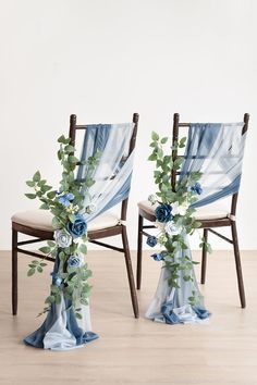 two chairs decorated with blue flowers and greenery