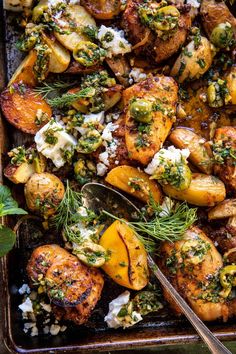 a pan filled with chicken and potatoes covered in herbs