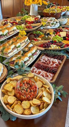 a table filled with lots of different types of sandwiches and appetizers on trays