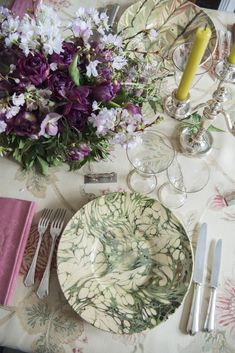 the table is set with flowers and silverware