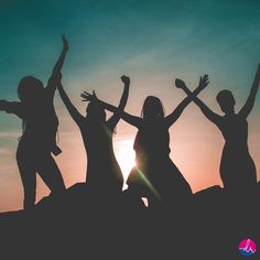 the silhouettes of four people are holding their arms in the air as the sun sets